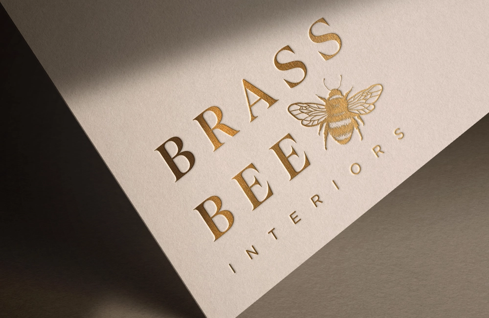 A sophisticated interior logo for Brass Bee Interiors, featuring a hand-sketched bumblebee
