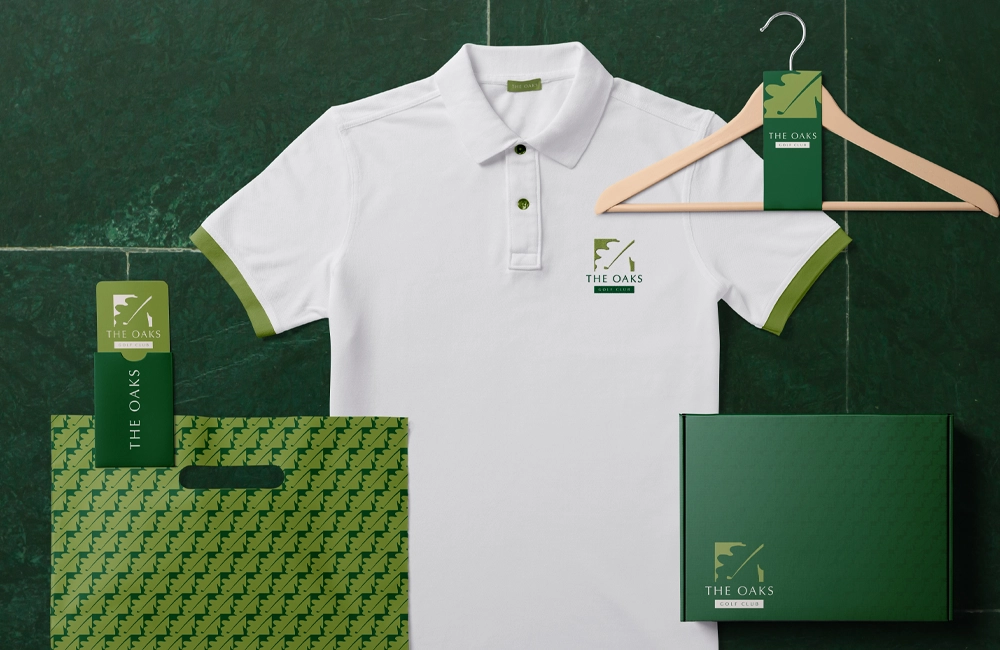 A clever negative space golfing logo for The Oaks Golf Course, in bright and darker greens.